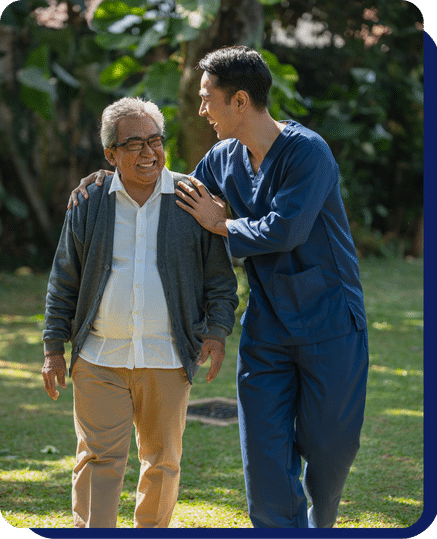 Caregiver assisting a senior man while walking outdoors