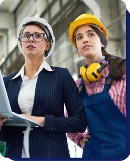 Industrial workers wearing helmets reviewing project plans on site