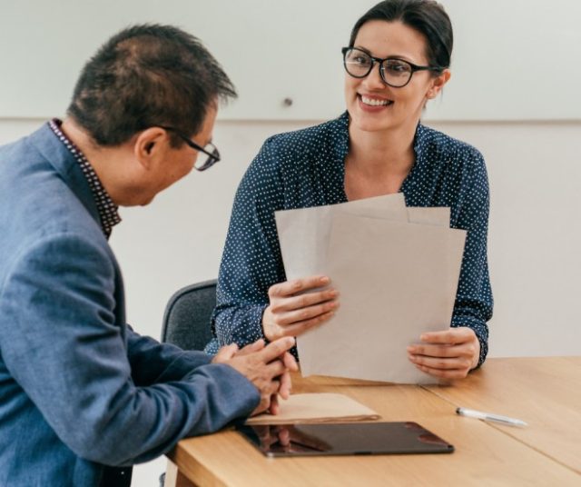 HR representative reviewing paperwork with candidate during background screening process