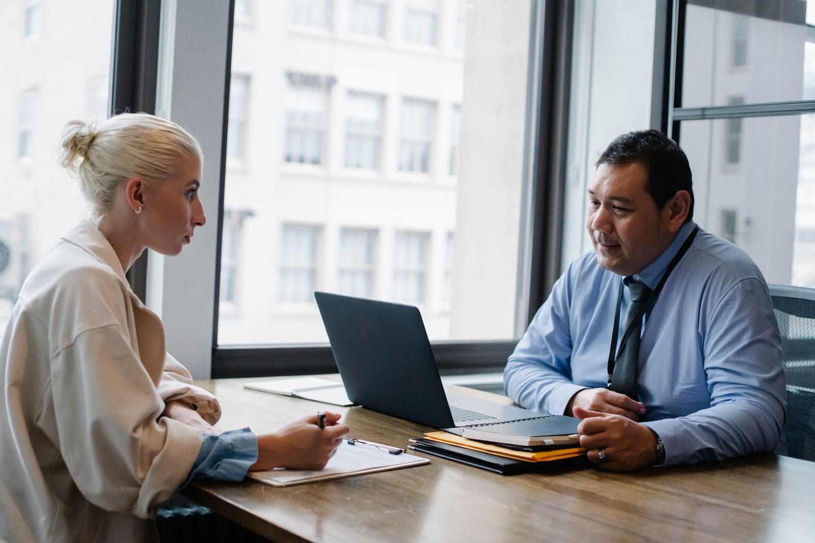 Applicant filling out an information form on a clipboard during a hiring meeting