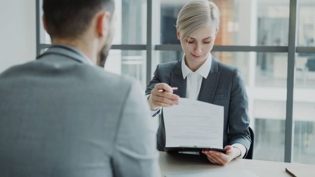 Hiring team reviewing background check paperwork and timelines in an office